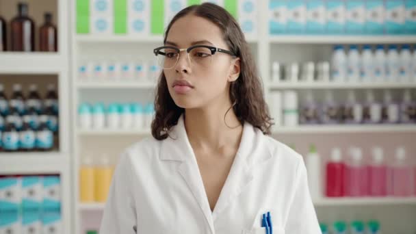 若いアフリカ系アメリカ人女性薬剤師が薬局で真剣な表情で立っています — ストック動画