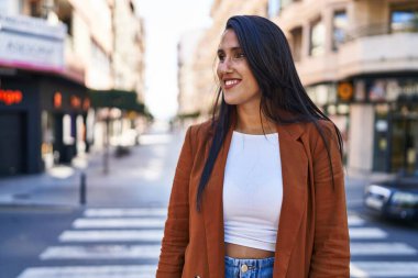 Sokakta kendine güvenen genç İspanyol kadın gülümsüyor