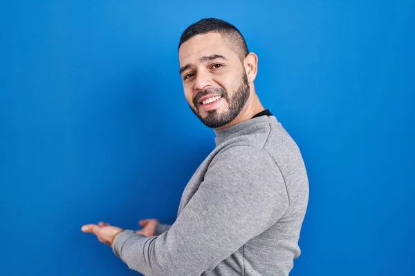 Hispanic Man Standing Blue Background Inviting Enter Smiling Natural Open — Photo