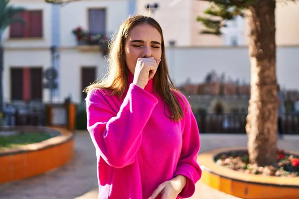 Young woman coughing at park