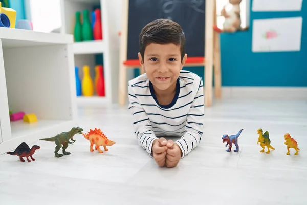 Adorável Menino Hispânico Brincando Com Dino Brinquedos Deitado Chão Jardim — Fotografia de Stock