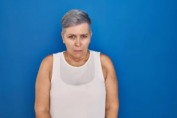 Orta Yaşlı Beyaz Bir Kadın Mavi Arka Planda Duruyor Şüpheci — Stok fotoğraf
