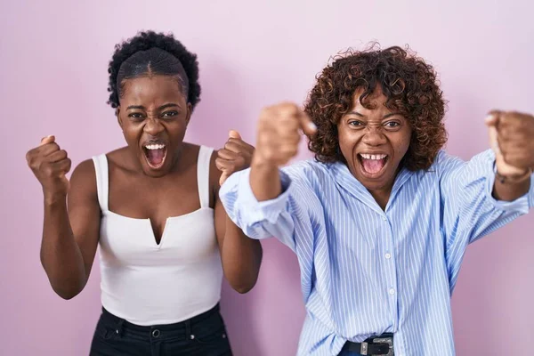 Duas Mulheres Africanas Sobre Fundo Rosa Com Raiva Punhos Levantando — Fotografia de Stock
