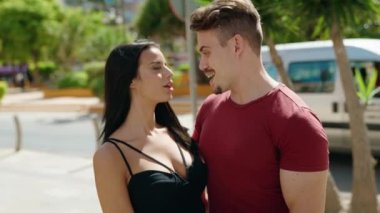 Erkek ve kadın çift sokakta birbirlerine sarılıyorlar.