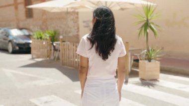 Sokakta kollarını kavuşturmuş genç, güzel İspanyol bir kadın.