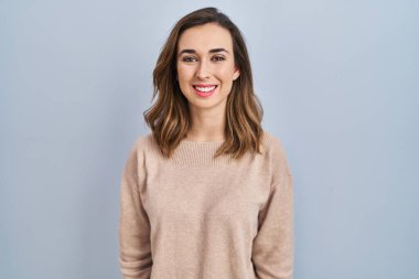 Soyutlanmış bir geçmişin başında mutlu ve havalı bir gülümsemeyle duran genç bir kadın. şanslı kişi. 