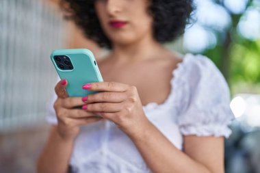 Young middle east woman using smartphone at street