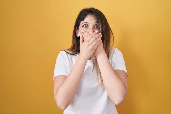 Young Brunette Woman Standing Yellow Background Shocked Covering Mouth Hands — Foto Stock