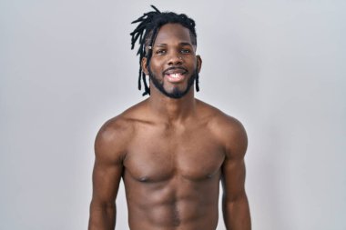 Sarışın Afrikalı adam izole edilmiş arka planda üstsüz duruyor. Olumlu ve mutlu görünüyor. Kendine güvenen bir gülümsemeyle dişlerini gösteriyor. 