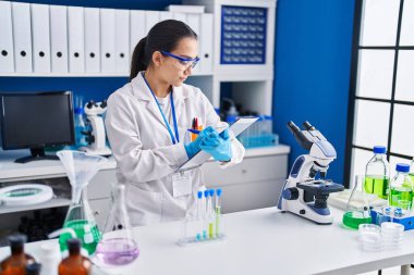 Laboratuvarda çalışan genç İspanyol kadın bilim adamı.