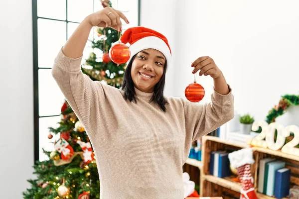 Hispanic Brunette Woman Holding Christmas Decorations Home — Zdjęcie stockowe