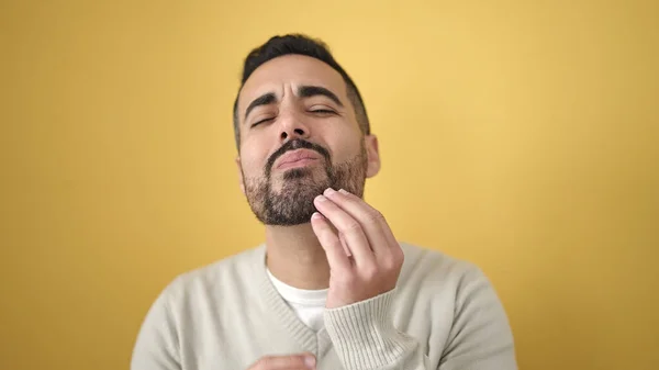 Young Hispanic Man Touching Beard Hands Isolated Yellow Background — Stockfoto