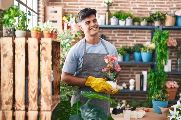 Jonge Spaanse Man Bloemist Glimlachend Zelfverzekerde Holding Plant Bloemenwinkel — Stockfoto