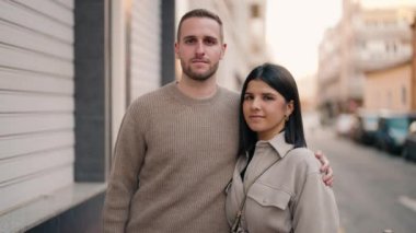 Young couple smiling confident hugging each other standing at street