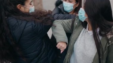 Anne ve kızları tıbbi maske takıyor.