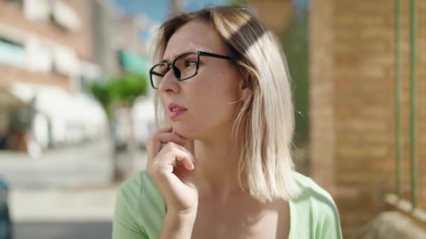 Νεαρή Γυναίκα Φορώντας Γυαλιά Στέκεται Αμφιβολία Έκφραση Στο Δρόμο — Αρχείο Βίντεο
