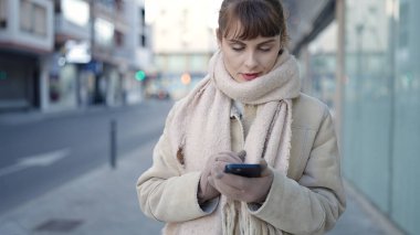 Young caucasian woman using smartphone at street