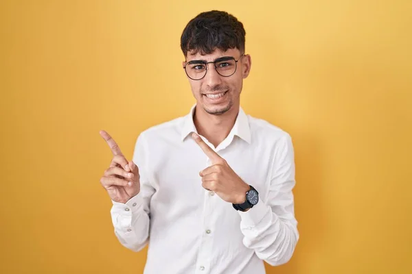 Mladý Hispánec Stojící Nad Žlutým Pozadím Ukazuje Ustaraně Nervózně Oběma — Stock fotografie