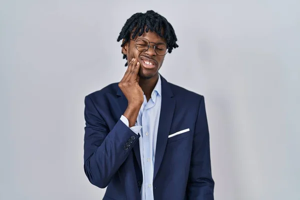 歯の痛みや歯の病気のために痛みを伴う表現で手で口に触れる白い背景にビジネスジャケットを身に着けているドレッドロックを持つ若いアフリカ人男性 歯科医 — ストック写真