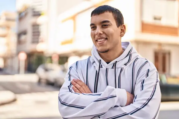 stock image Young man smiling confident standing with arms crossed gesture at street