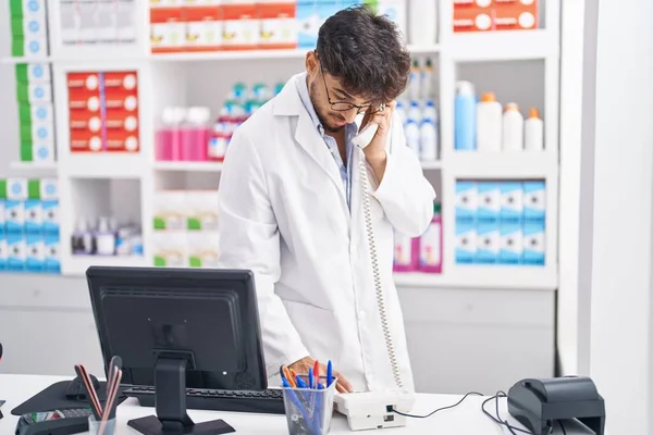 Young Arab Man Pharmacist Using Computer Talking Telephone Pharmacy — Zdjęcie stockowe