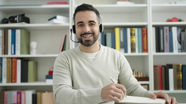 Young Hispanic Man Student Having Video Call Writing Notebook Library — Stockfoto