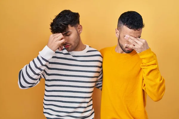 Young Hispanic Gay Couple Standing Yellow Background Tired Rubbing Nose — Stock fotografie