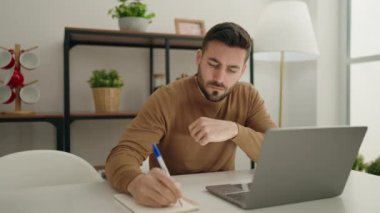 Genç İspanyol adam masada oturup ders çalışıyor.