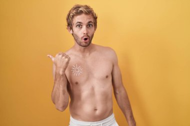 Beyaz, üstsüz, güneş kremi sürmüş bir adam elleri yana dönük, ağzı açık bir şekilde şaşkınlık içinde.. 