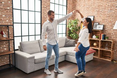 Man and woman couple smiling happy dancing at home