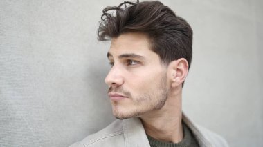 Young hispanic man standing with serious expression over isolated white background