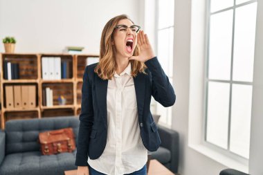 Young woman working at consultation office clueless and confused with open arms, no idea and doubtful face. 