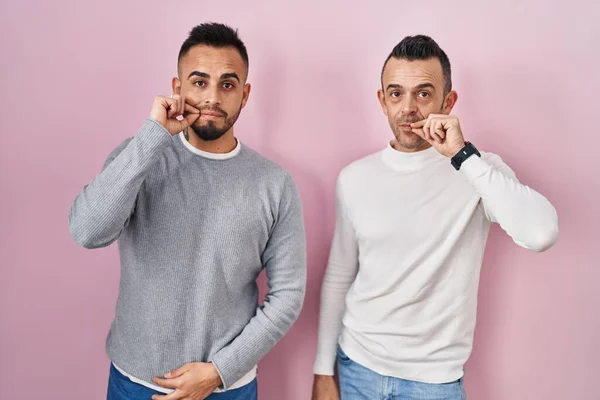Homosexual Couple Standing Pink Background Mouth Lips Shut Zip Fingers — Stockfoto