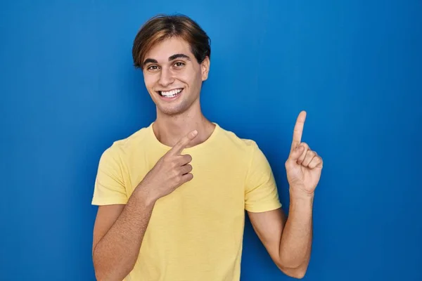 Mavi Arka Planda Duran Genç Adam Gülümsüyor Kameraya Bakıyor Iki — Stok fotoğraf