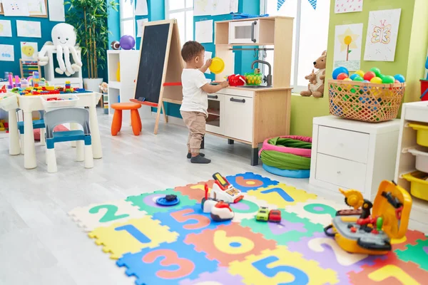 Adorable Hispanic Toddler Playing Play Kitchen Standing Kindergarten — Stockfoto