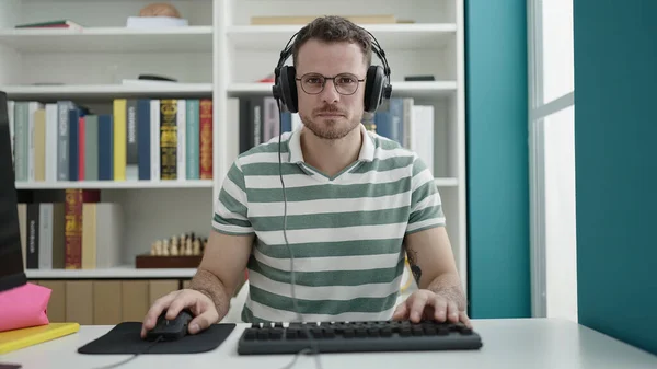 Young Caucasian Man Using Computer Wearing Headphones Library University — Stockfoto