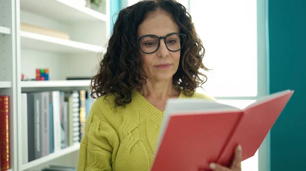 Middle Age Hispanic Woman Teacher Reading Book Library University — Stok fotoğraf