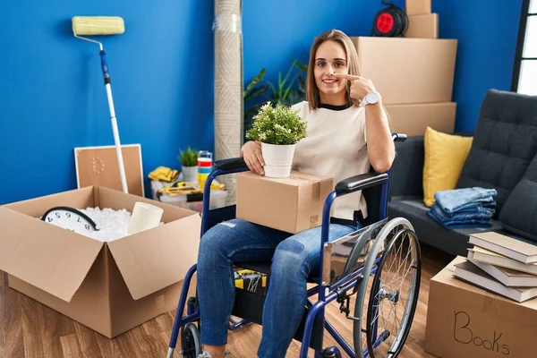 Młoda Kobieta Siedząca Wózku Inwalidzkim Poruszająca Się Nowego Domu Wskazująca — Zdjęcie stockowe
