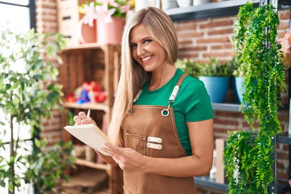 Young Blonde Woman Florist Smiling Confident Writing Notebook Flower Shop — Stock Photo, Image