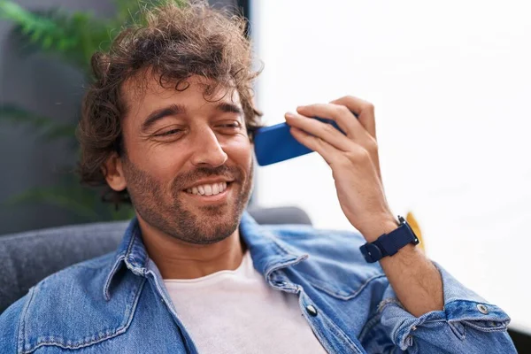 Jovem Hispânico Homem Ouvir Mensagem Voz Por Smartphone Sentado Sofá — Fotografia de Stock