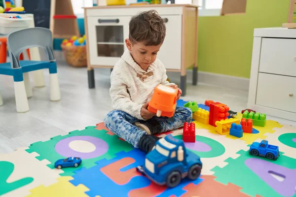愛らしいヒスパニック幼児遊びとともに車おもちゃ座っています床に幼稚園 — ストック写真