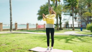 Genç Afrikalı Amerikalı kadın parkta yoga eğitimi alıyor.