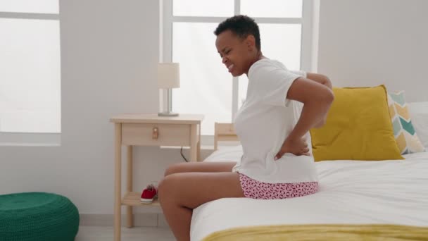 Afrikansk Amerikansk Kvinna Som Lider För Ryggskada Sittande Sängen Sovrummet — Stockvideo
