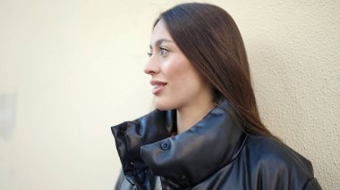 Young beautiful hispanic woman smiling confident looking to the side at street