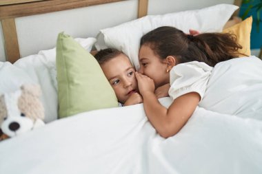 Erkek ve kız kardeş kitap okuyor yatak odasındaki Noel süslemesinde kanepede oturuyorlar.