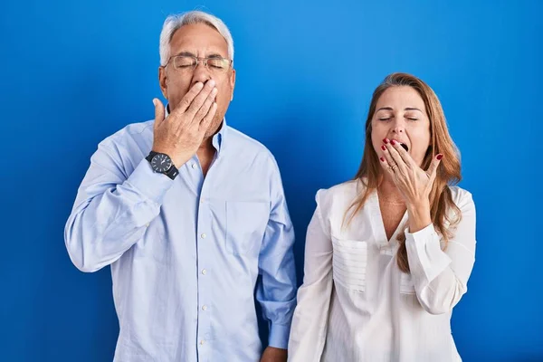 Middle Age Hispanic Couple Standing Blue Background Bored Yawning Tired —  Fotos de Stock