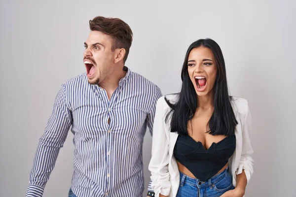 Young Hispanic Couple Standing White Background Angry Mad Screaming Frustrated — Stock Fotó