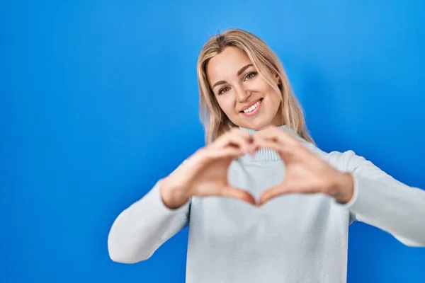 Young Caucasian Woman Standing Blue Background Smiling Love Doing Heart — Foto de Stock