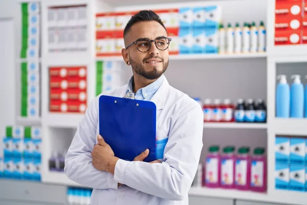 Young Hispanic Man Pharmacist Holding Clipboard Pharmacy — Fotografia de Stock