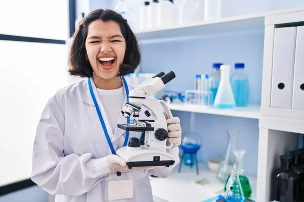 Young Hispanic Woman Working Scientist Laboratory Holding Microscope Smiling Laughing — Stock fotografie